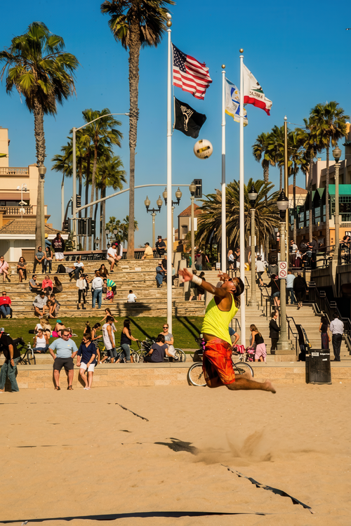 Free Action-packed beach volleyball match with a vibrant crowd on a sunny day by the coast. Stock Photo