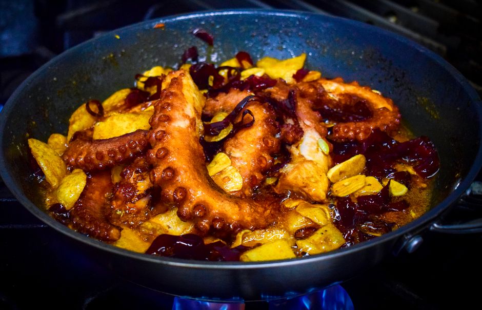 Delicious octopus cooked with garlic and chili in a pan.