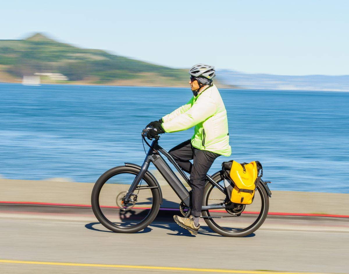 Cyclist riding with a pannier bag on a scenic road