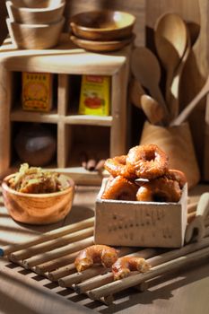 A rustic kitchen scene featuring traditional Indonesian snacks and wooden utensils. - Fotografer Sidoarjo