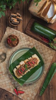 Traditional Indonesian dish served on banana leaf with sambal, beautifully presented on woven mat. - Fotografer Sidoarjo