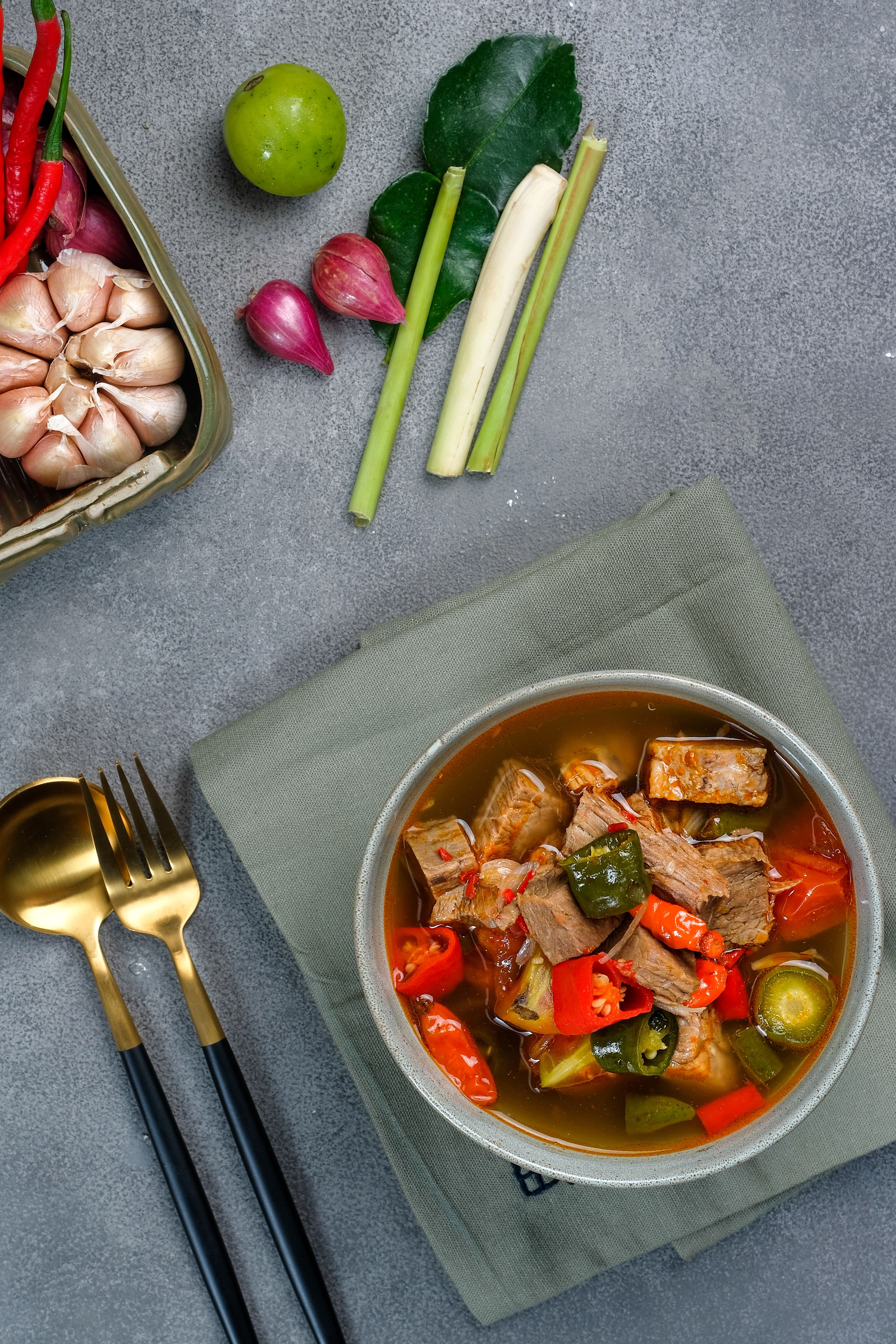 Delicious Indonesian beef soup with fresh herbs and vegetables, styled with modern flat lay design.
