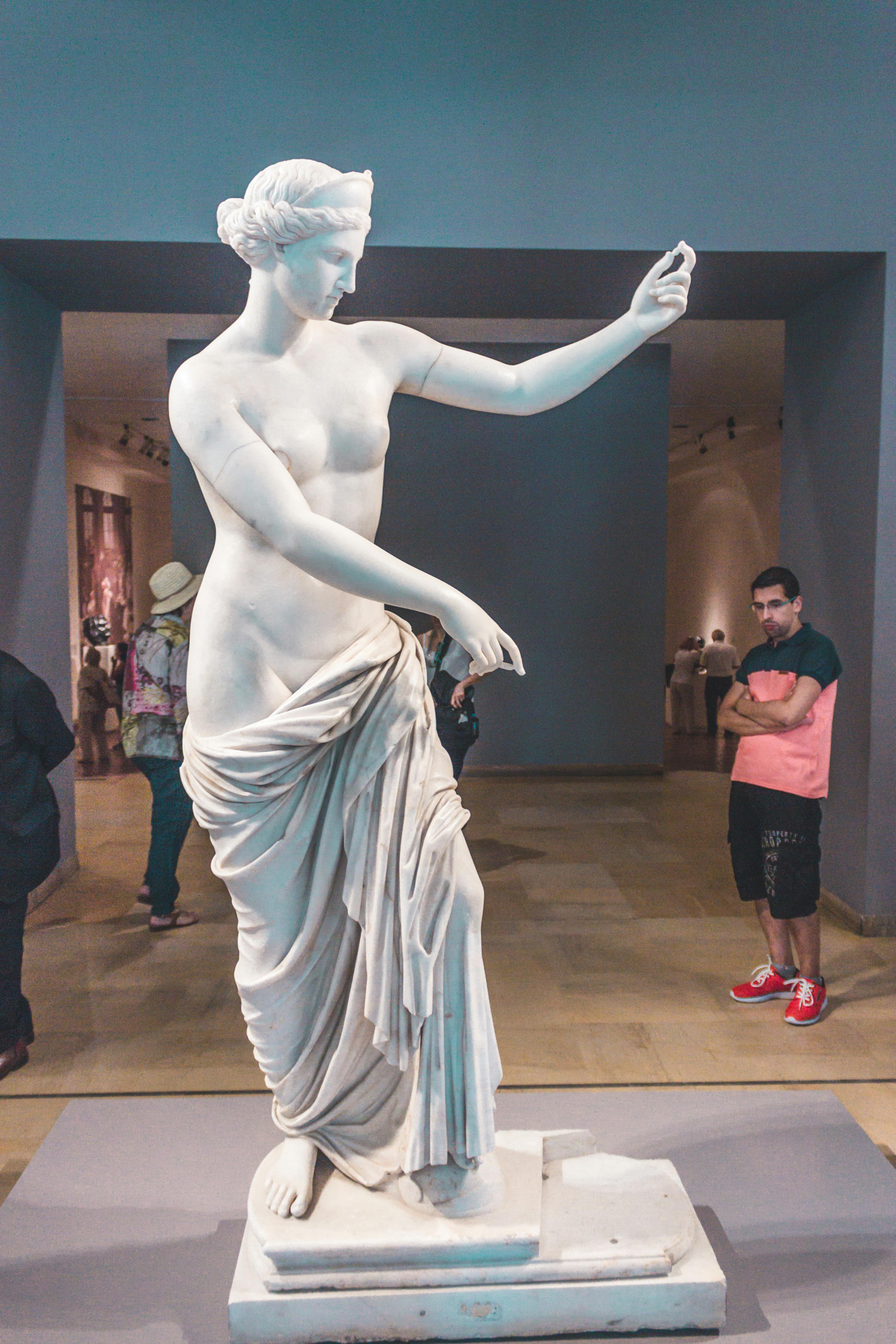 Photo of a man Looking at a Statue