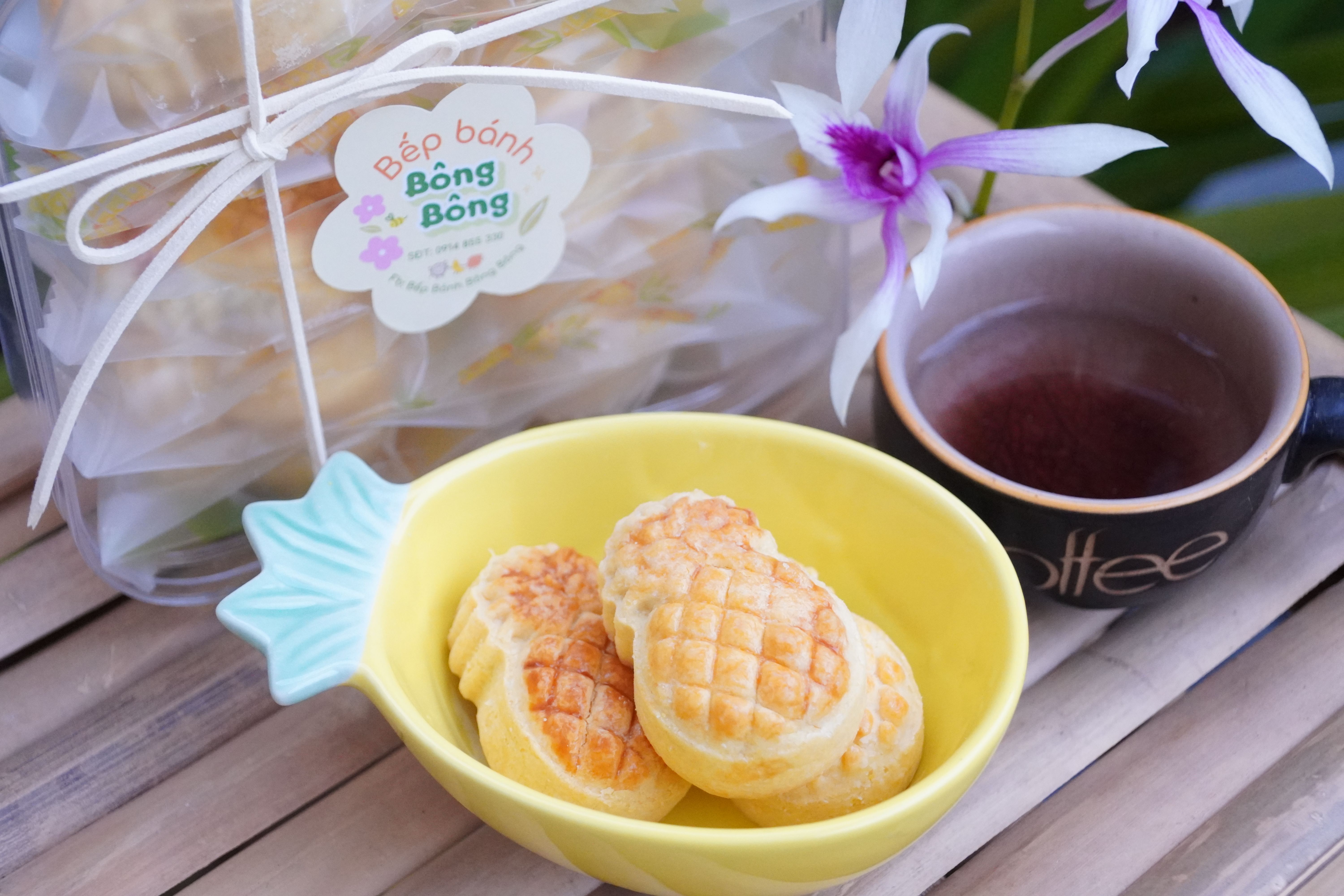 Pineapple-shaped pastries served with tea and an orchid, creating a tropical vibe.