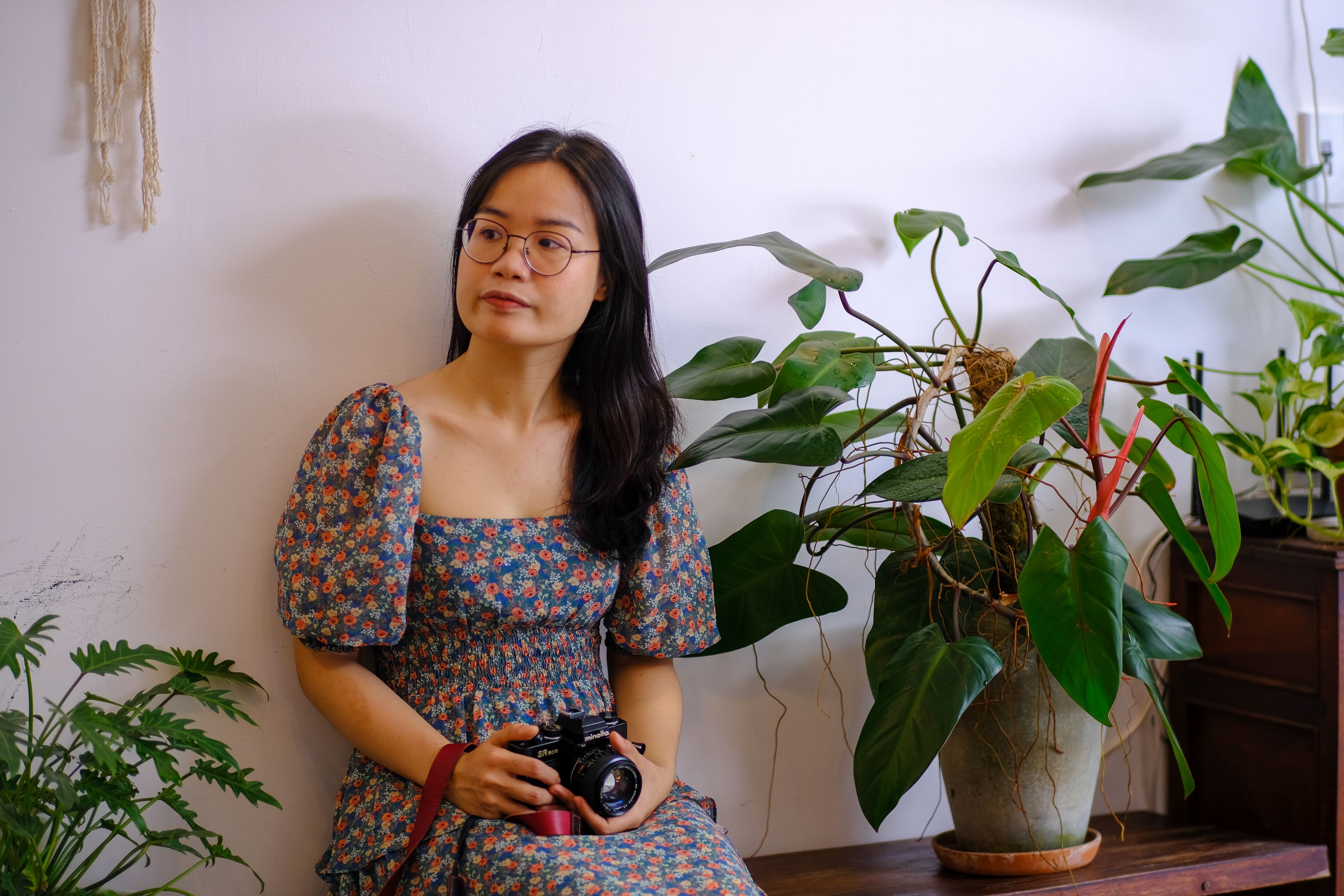 Portrait of a woman with a camera in an indoor plant setting, Hue, Vietnam.