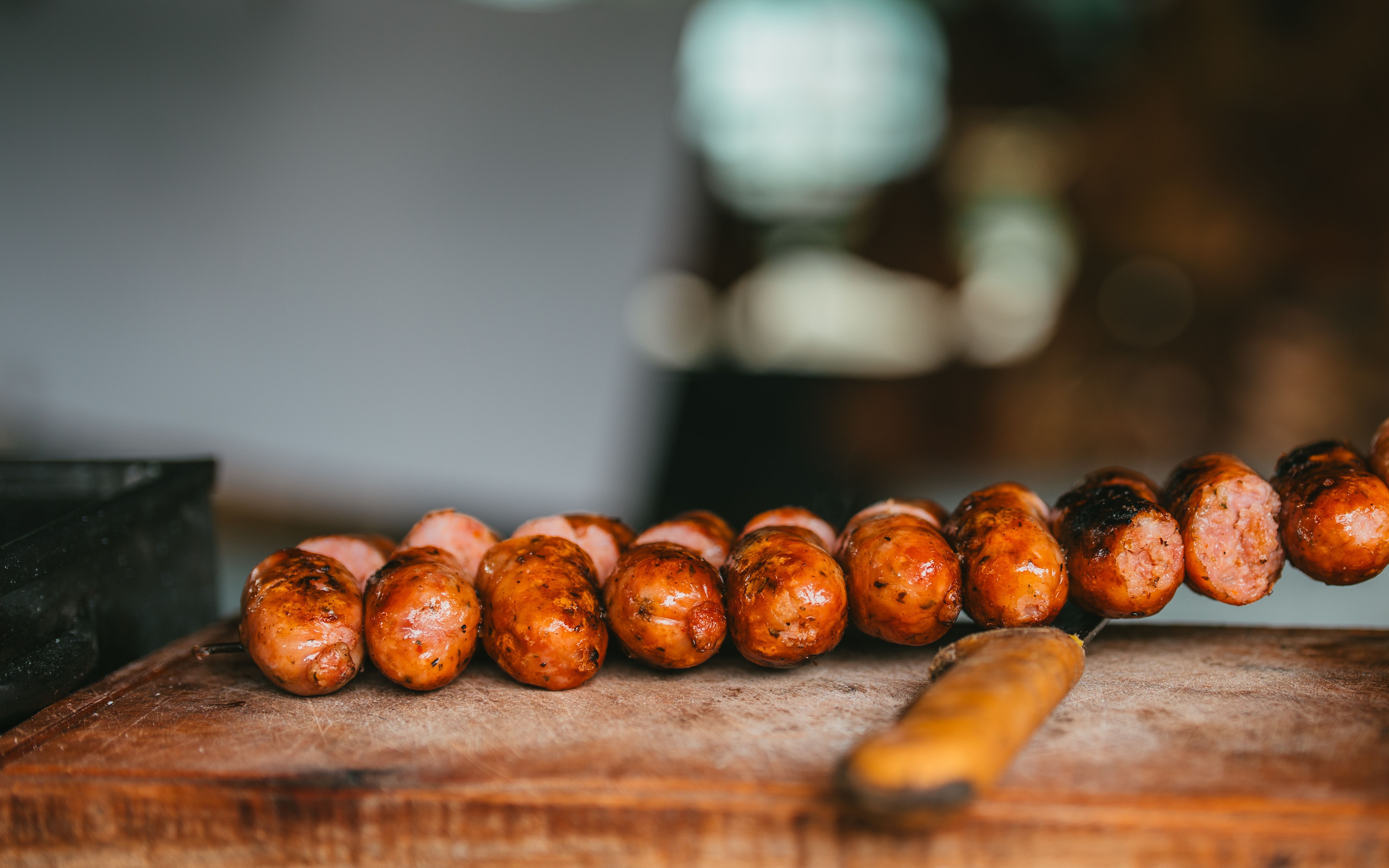 Sliced chorizo sticks arranged in a line on a wooden cutting board`