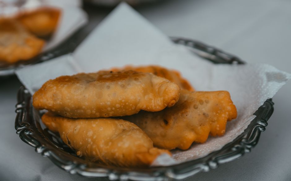 Delicious pastizzi, a traditional Maltese pastry with ricotta filling, on a street vendor's tray in Malta.