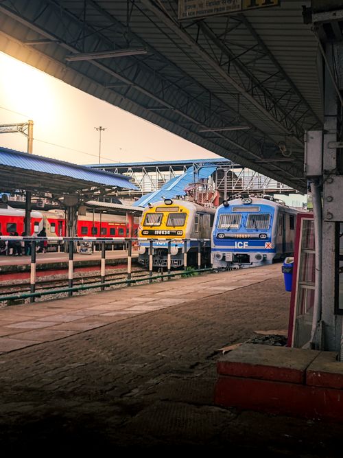 Free A busy train station in India with two trains under a vibrant sunset sky, showcasing railway travel. Stock Photo