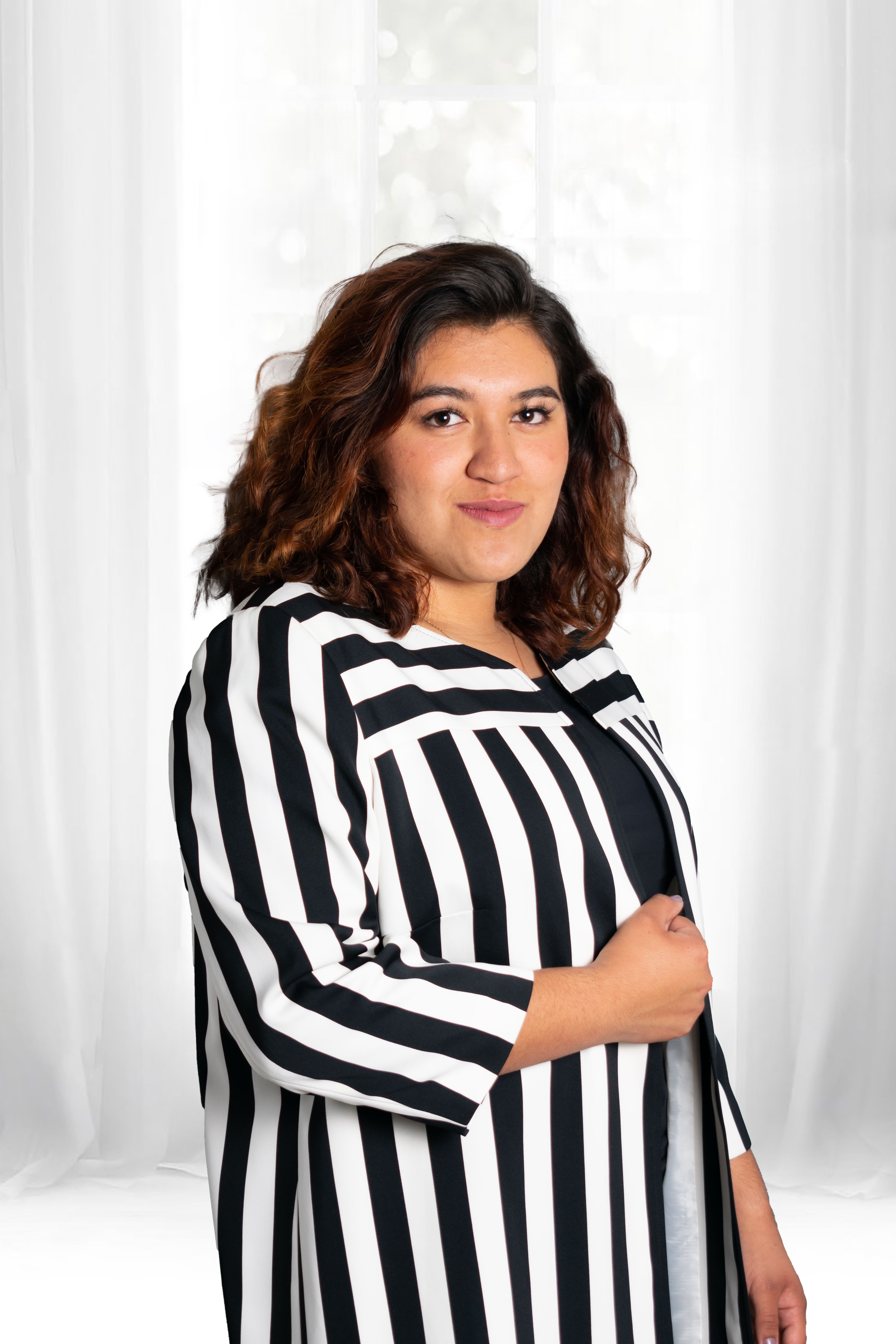 Portrait of a confident woman in black and white stripes posing indoors in Lerma, Estado de México.
