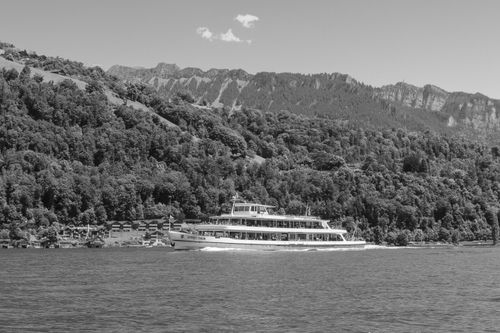 Free Black and white photo of a cruise ship on Lake Brienz with picturesque mountain backdrop. Stock Photo