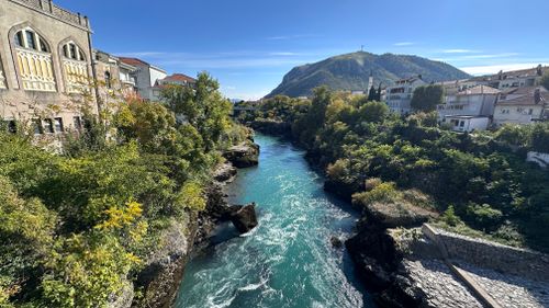 Free Stunning landscape of Neretva River in Mostar with clear blue water and lush greenery. Stock Photo