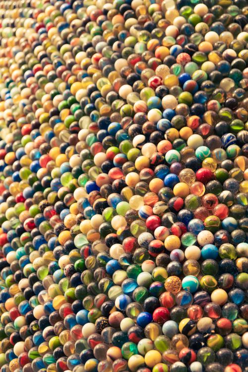 Free A vibrant collection of colorful marbles creating a textured pattern, showcasing diversity and playfulness. Stock Photo