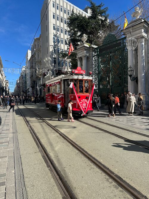 Free Red tram travels down İstiklal Avenue, Istanbul with bustling pedestrians and iconic architecture. Stock Photo