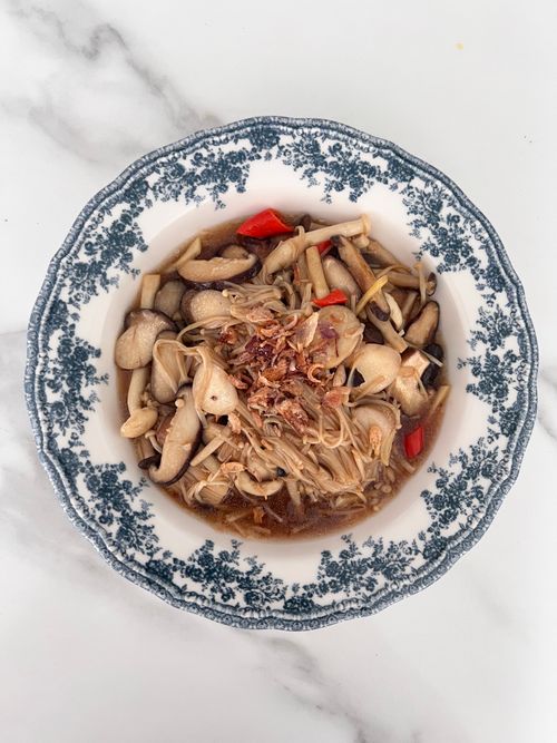 Free A flavorful mixed mushroom soup served in a blue and white porcelain bowl on a marble surface. Stock Photo