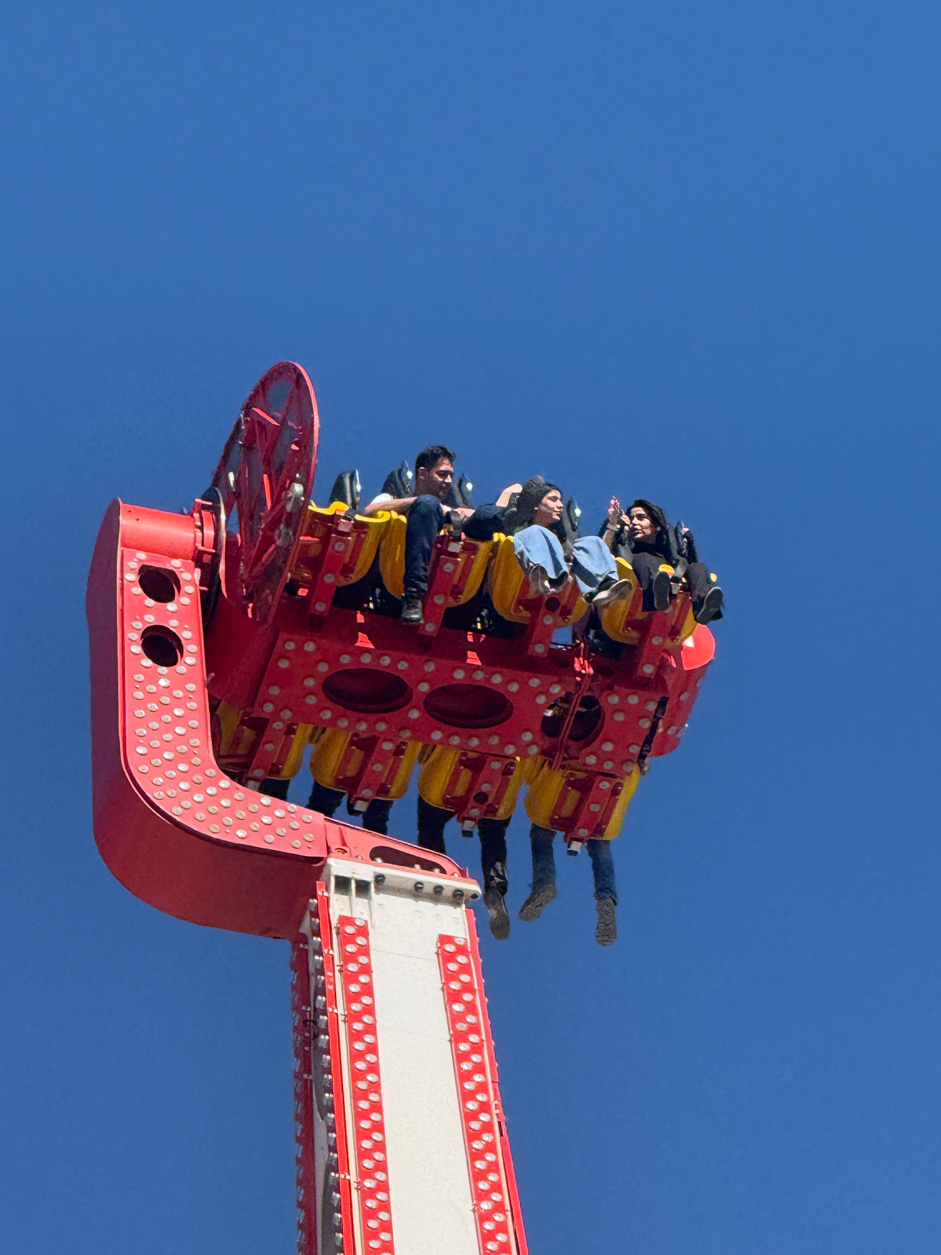 Thrilling Amusement Park Ride Against Clear Blue Sky · Free Stock Photo
