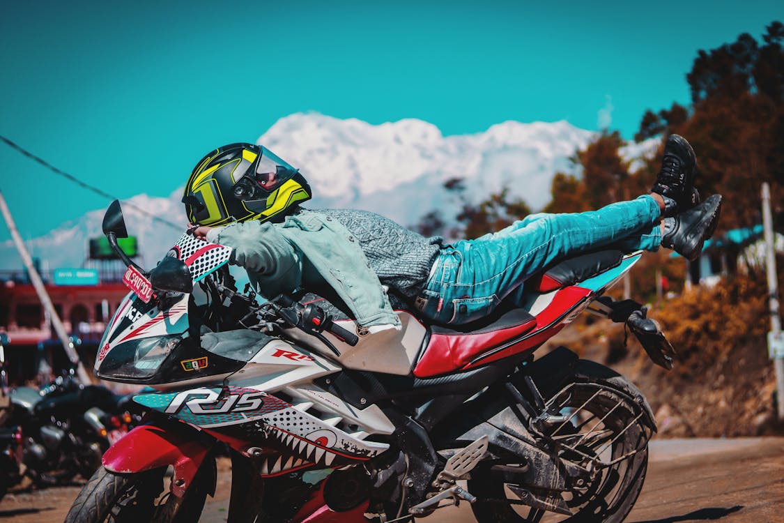 Free Man in Green Jacket Riding Red and Black Sports Bike Stock Photo