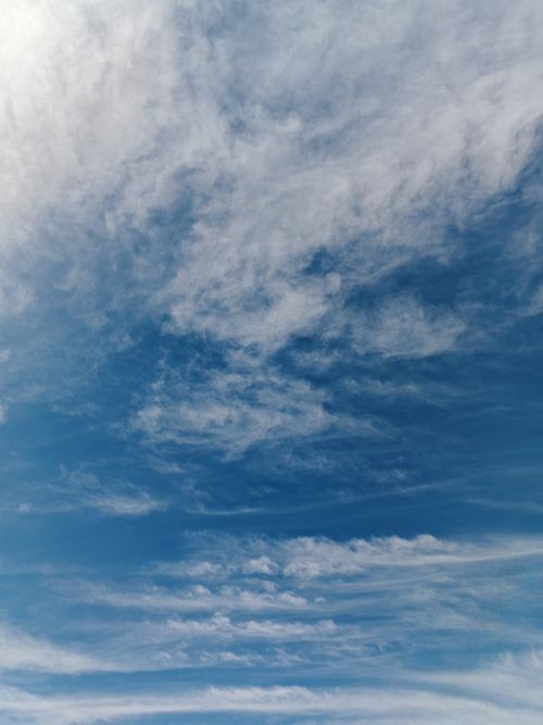 Free A serene view of a blue sky filled with wispy white clouds, embodying tranquility and openness. Stock Photo