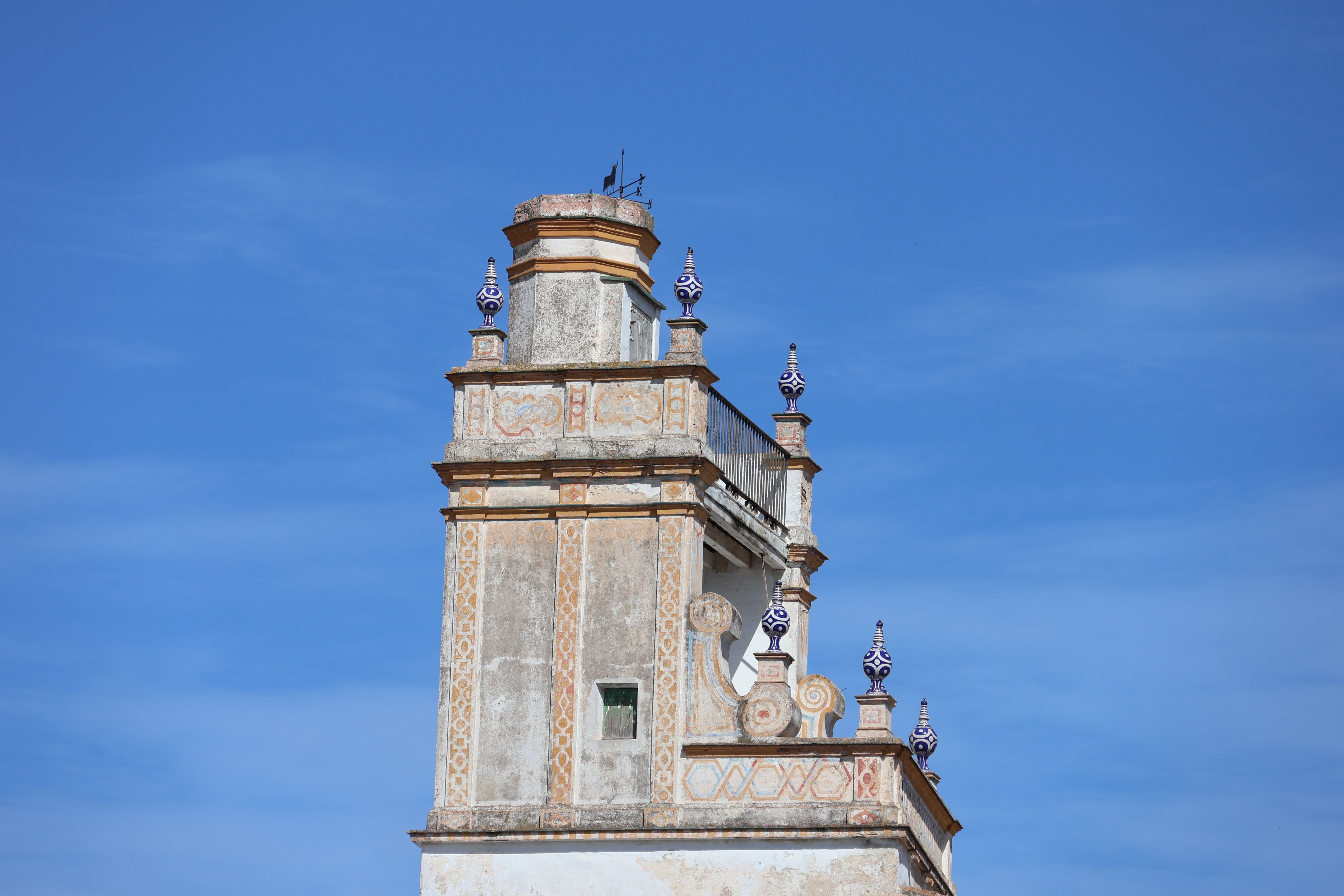 Elevated view of a historic tower against a clear blue sky in El Puerto de Santa María, Spain.