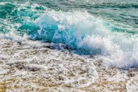 动态的海浪捕捉到了海滩场景的活力本质，碧绿的海水在海岸上飞溅