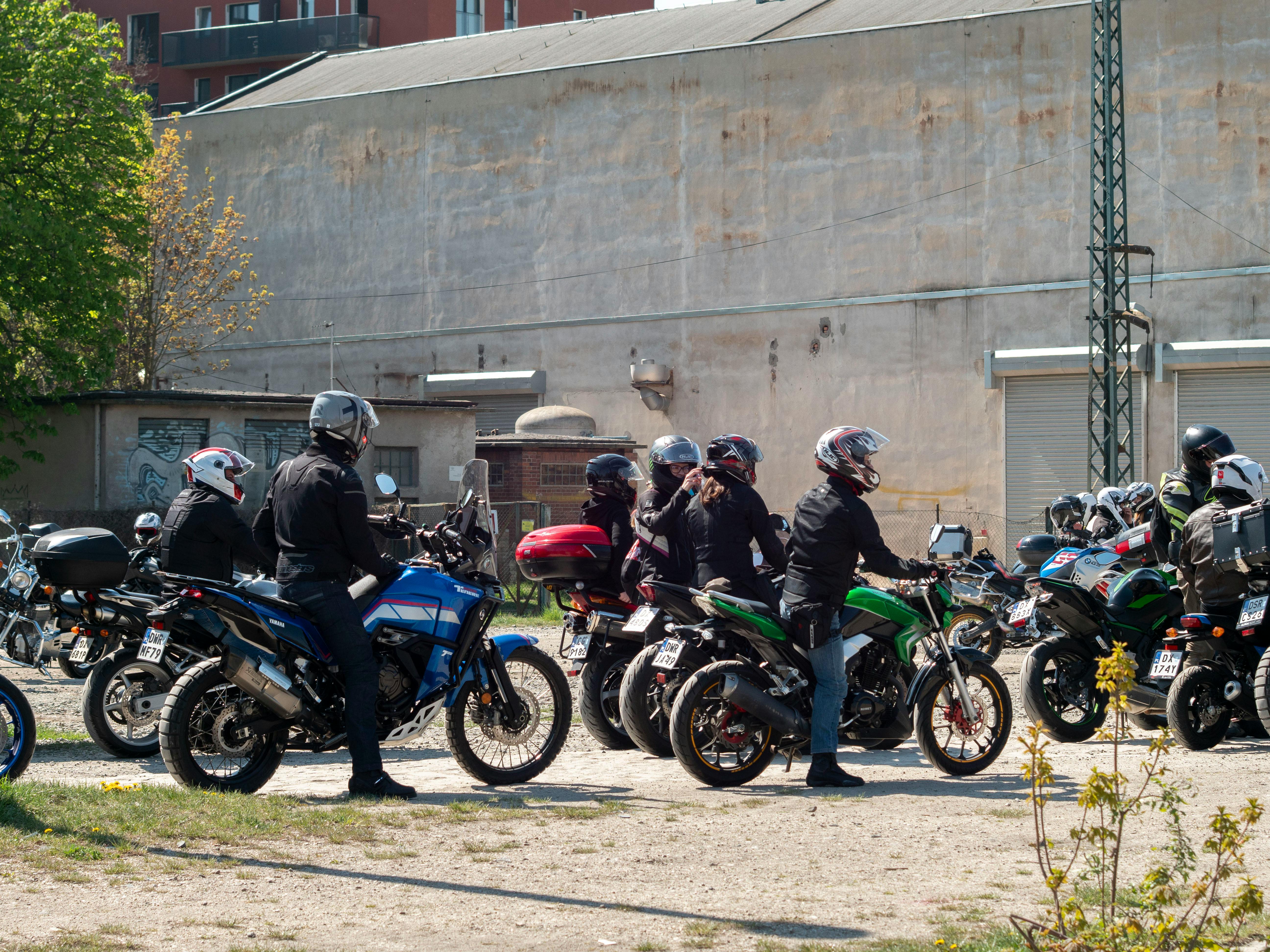 Group of motorcyclists on various bikes gathering outdoors in Wrocław, Poland.