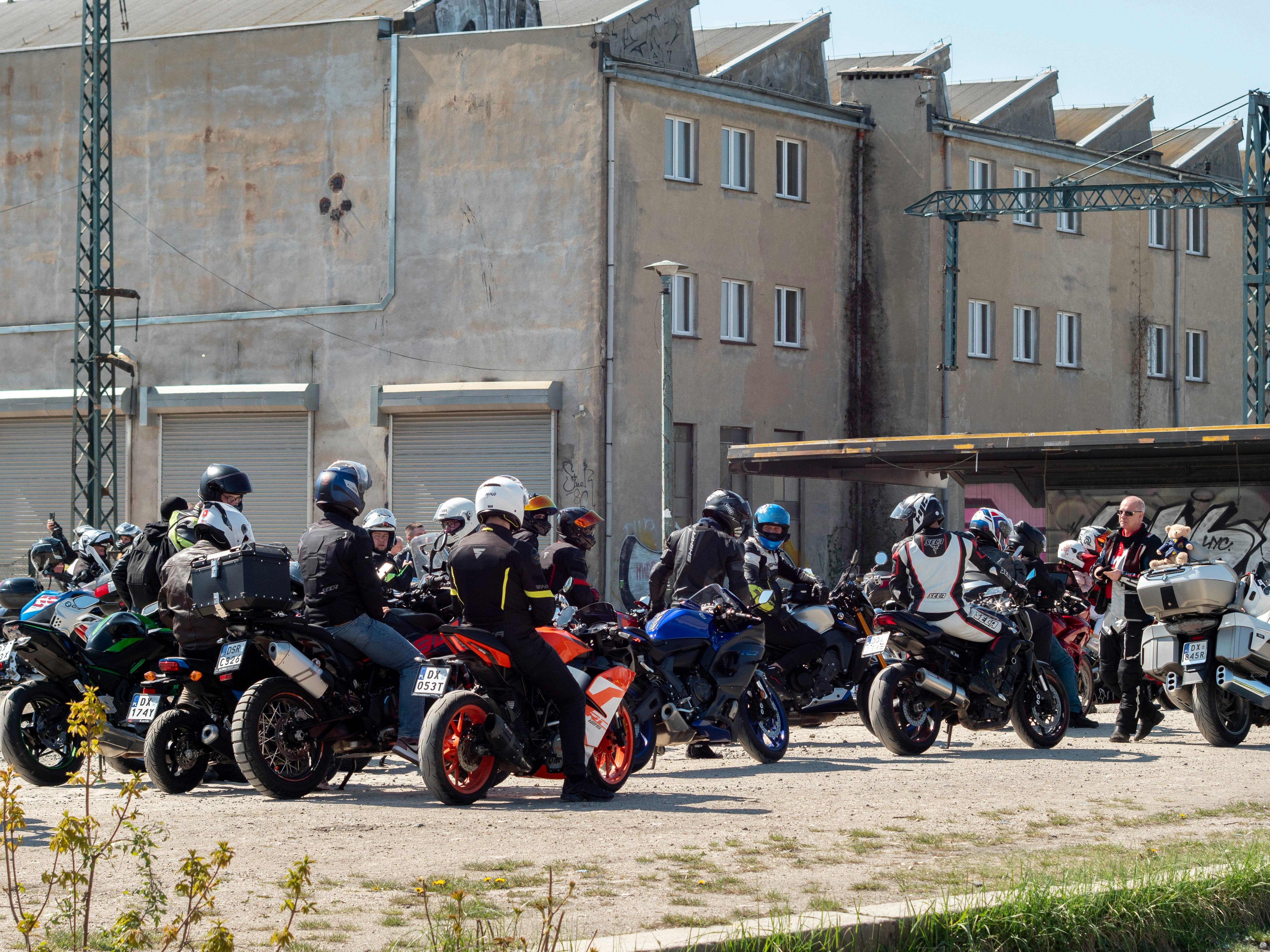Motorcyclists gathered together with their bikes in Wrocław, Poland on a sunny day.