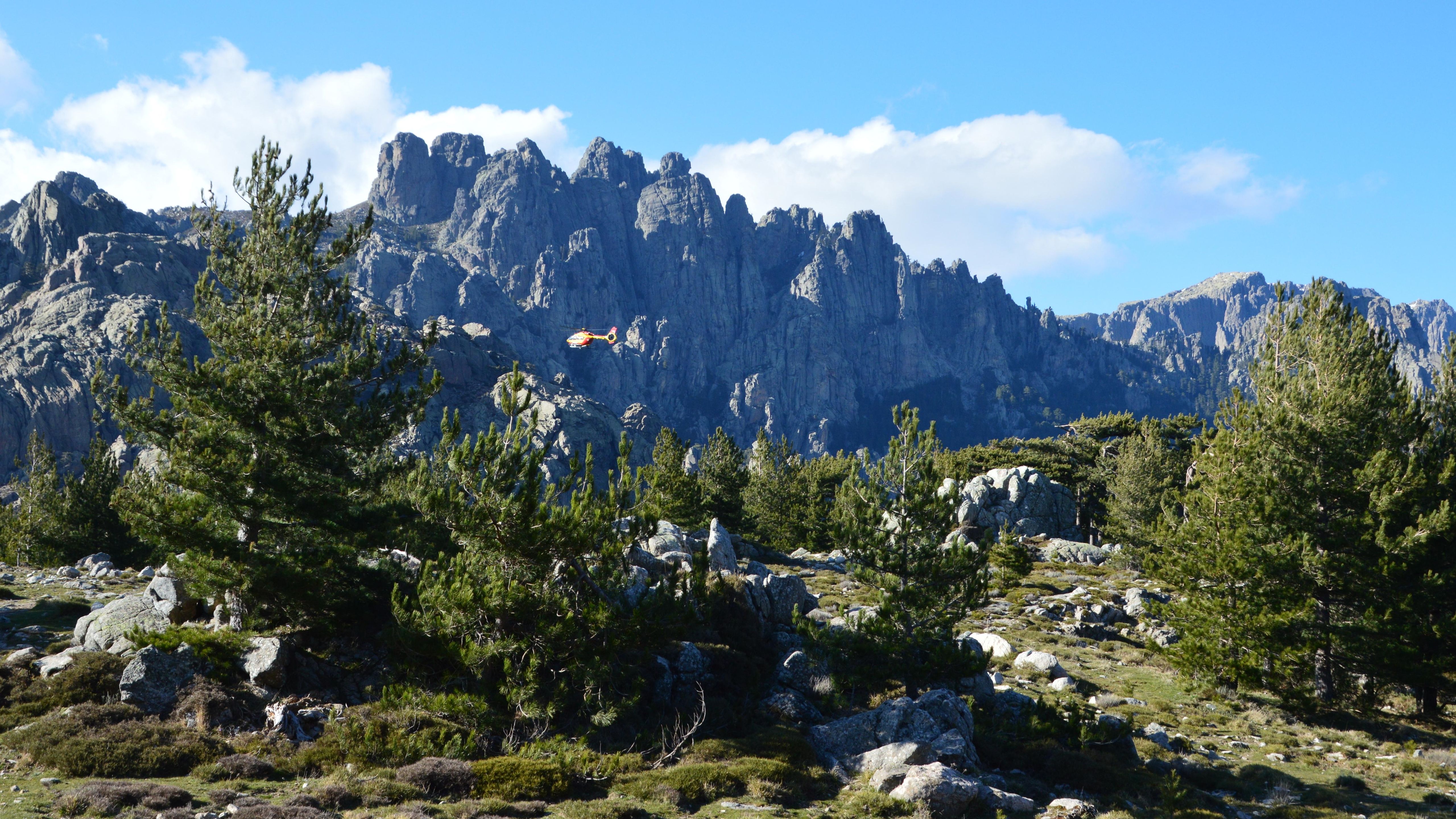 Stunning view of Corsican mountains with lush greenery and helicopter in Zonza, Corse.
