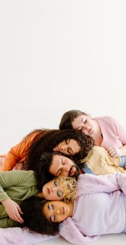 Five friends lying closely together indoors, conveying warmth and comfort.