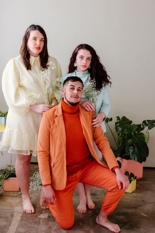 Free Trio posing elegantly with modern fashion and floral arrangement, perfect for lifestyle themes. Stock Photo