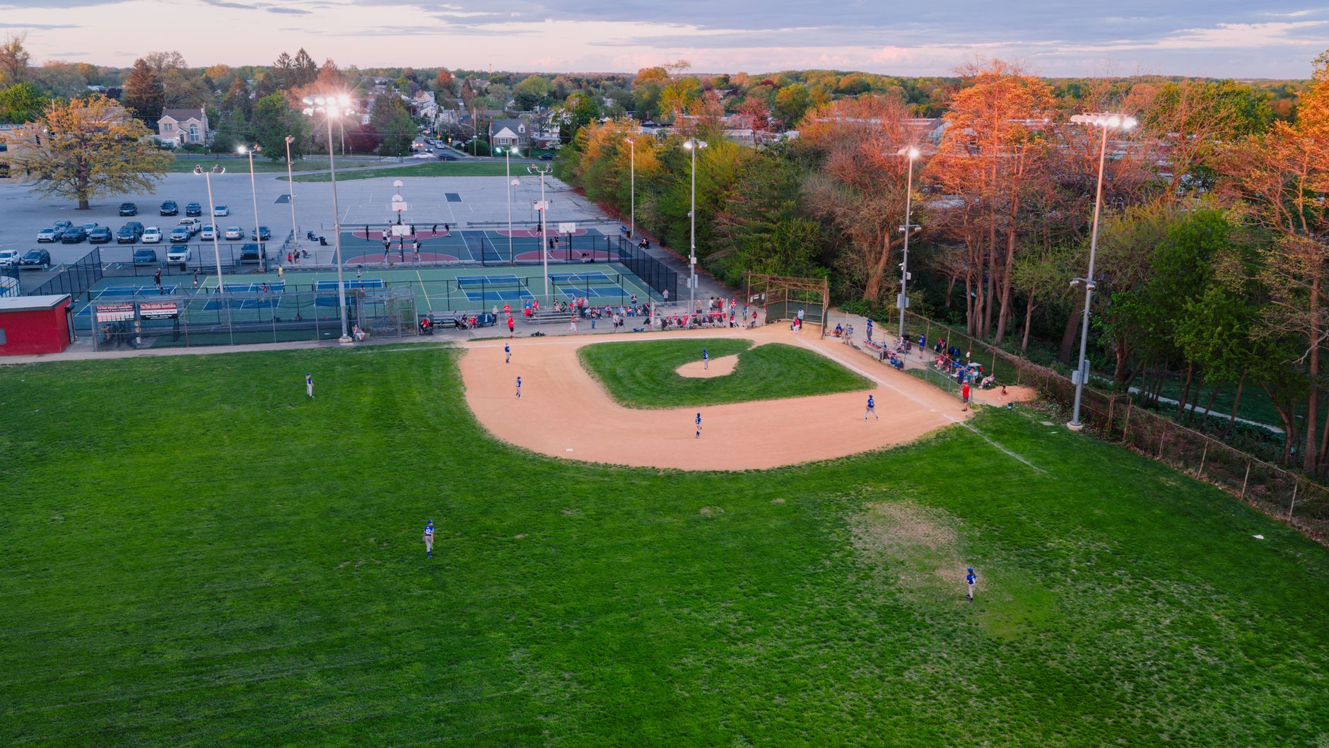 Aerial view capturing a baseball game in a Philadelphia park during sunset.