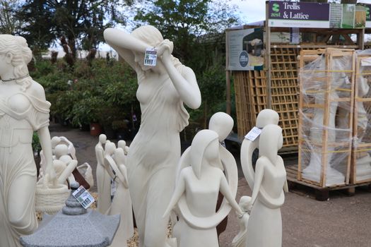 Elegant collection of marble garden statues displayed in an outdoor garden center.