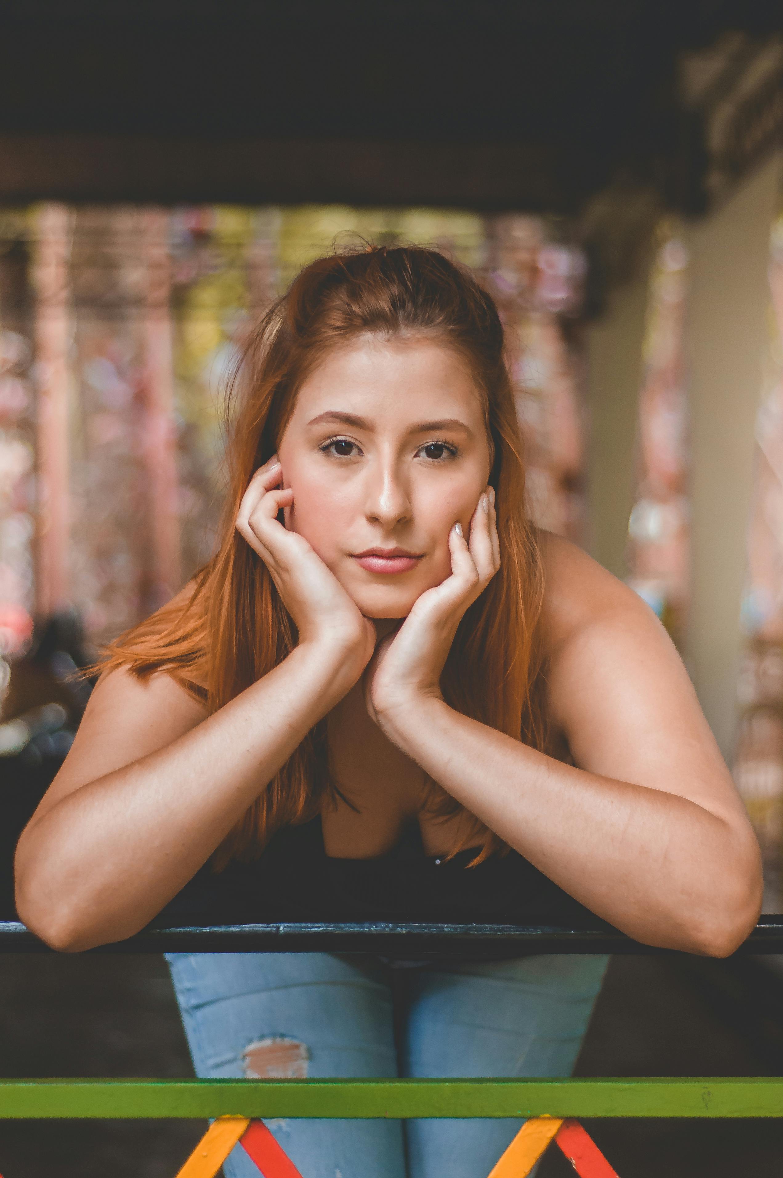 一位年轻女子倚靠栏杆的肖像，拍摄于户外