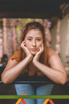 一位年轻女子倚靠栏杆的肖像，拍摄于户外