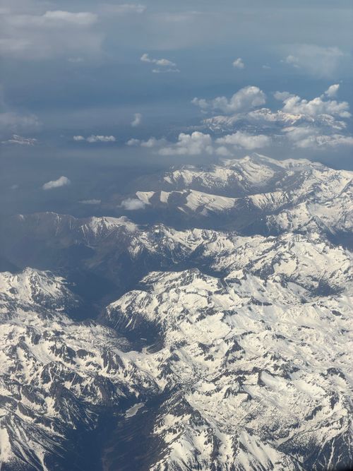 Free Breathtaking aerial view of snow-covered mountain peaks with clear skies above. Stock Photo