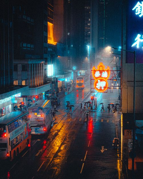 Free Neon lights reflect on wet streets in a vibrant Asian city at night, capturing urban nightlife energy. Stock Photo