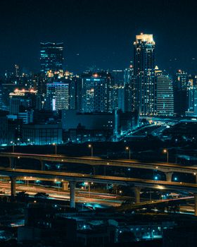 A vibrant nighttime cityscape featuring glowing skyscrapers and intricate highways under the city lights.