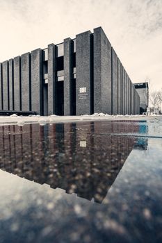 Modern architectural building with reflection in a puddle, Katowice, Poland.