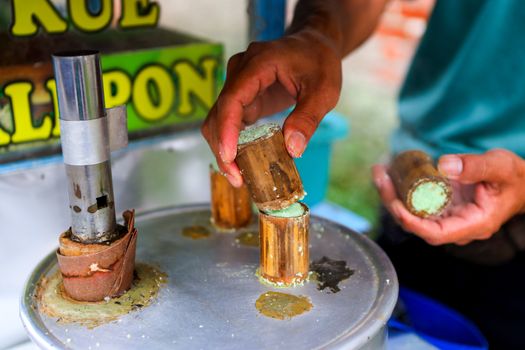 Close-up of traditional Putu cake preparation in Bandung, Indonesia, featuring steamed coconut and sugar treats.