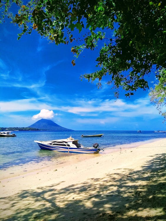 Free Boat Docked On Seashore Under Blue Sky Stock Photo