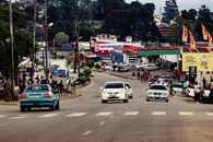 A bustling street in Manzini, Eswatini with vehicles and pedestrians capturing urban life.