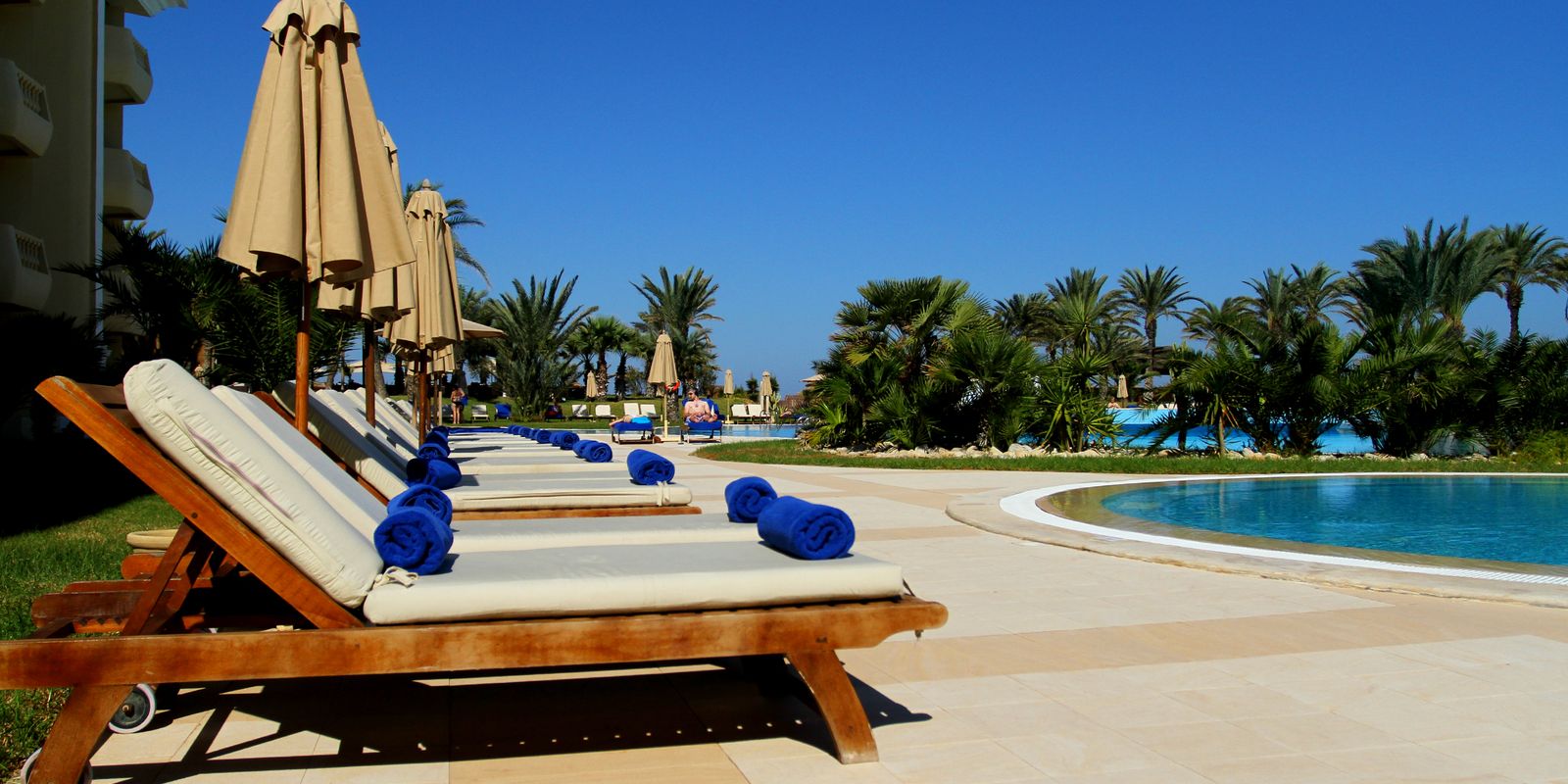 Luxury resort pool with loungers on a sunny summer day