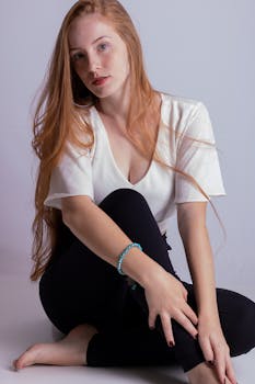 一位留着长发的年轻女子在室内轻松地随意摆着姿势