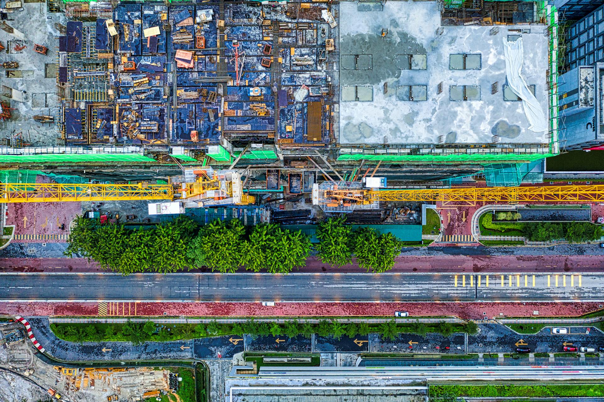 Top-down view of a construction site with cranes and urban landscape in Petaling Jaya, Malaysia.
