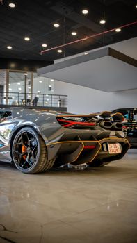 High-end sports car displayed in a modern automotive showroom, showcasing sleek design and luxury.