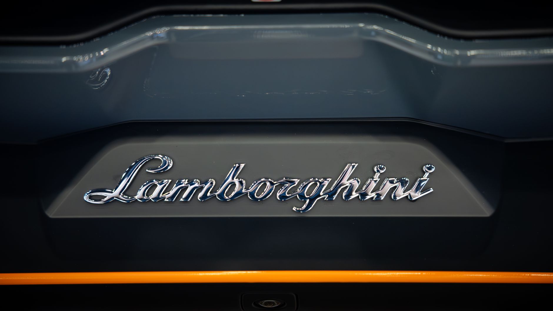 Detailed close-up view of the iconic Lamborghini logo on a car bumper, showcasing luxury and elegance.
