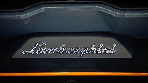 Free Detailed close-up view of the iconic Lamborghini logo on a car bumper, showcasing luxury and elegance. Stock Photo