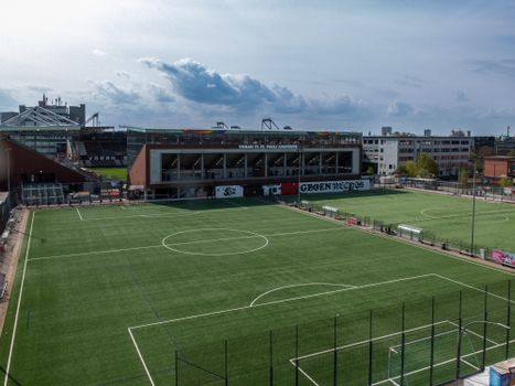 An aerial view of an empty soccer field and stadium in the city.