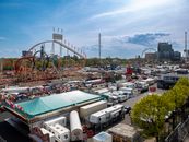 Colorful amusement park with roller coasters and ferris wheel on a sunny day.