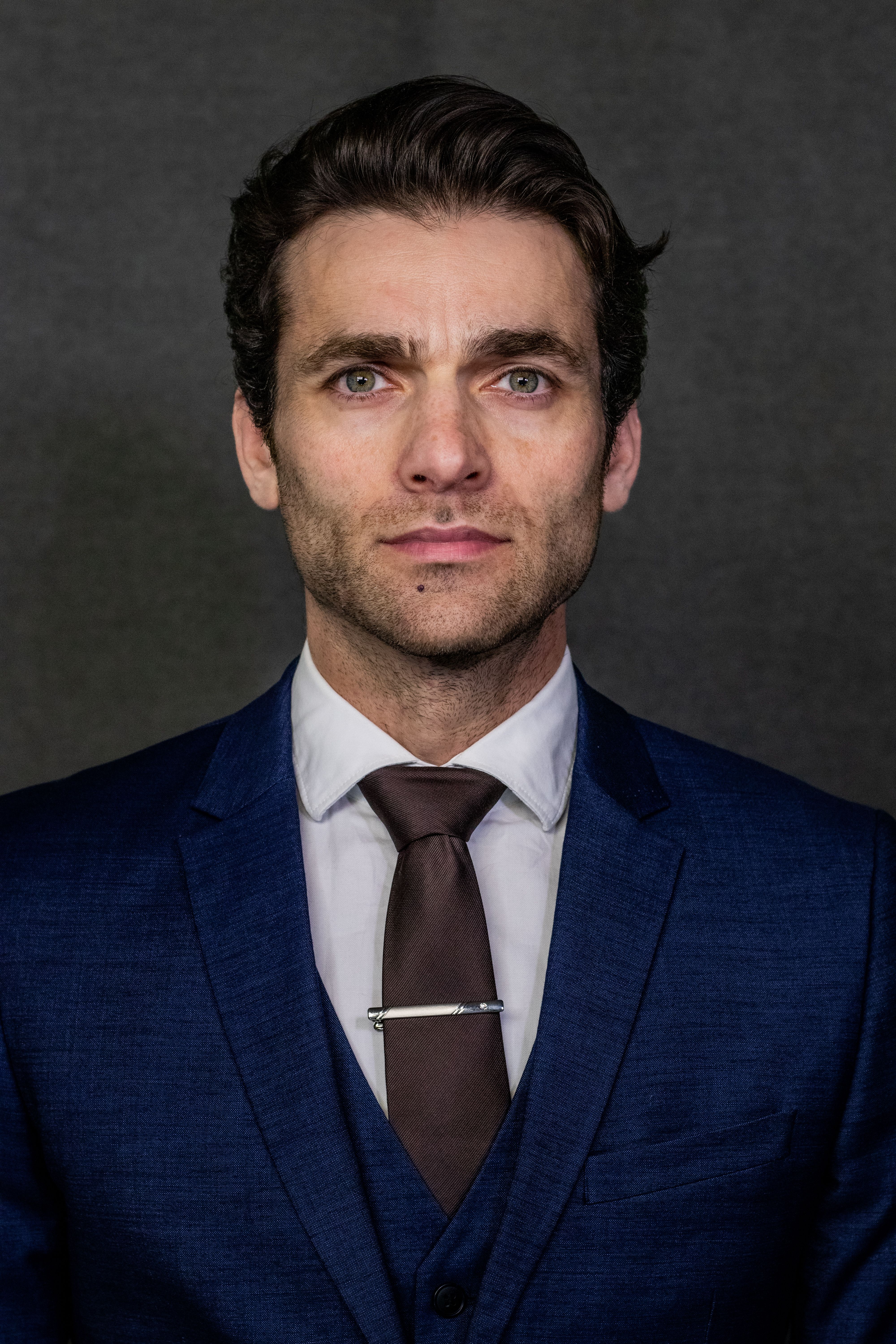 Confident business professional in a blue suit, looking directly at the camera.