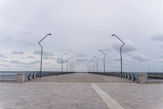 A tranquil view of an empty promenade with street lamps by the Caspian Sea in Baku.