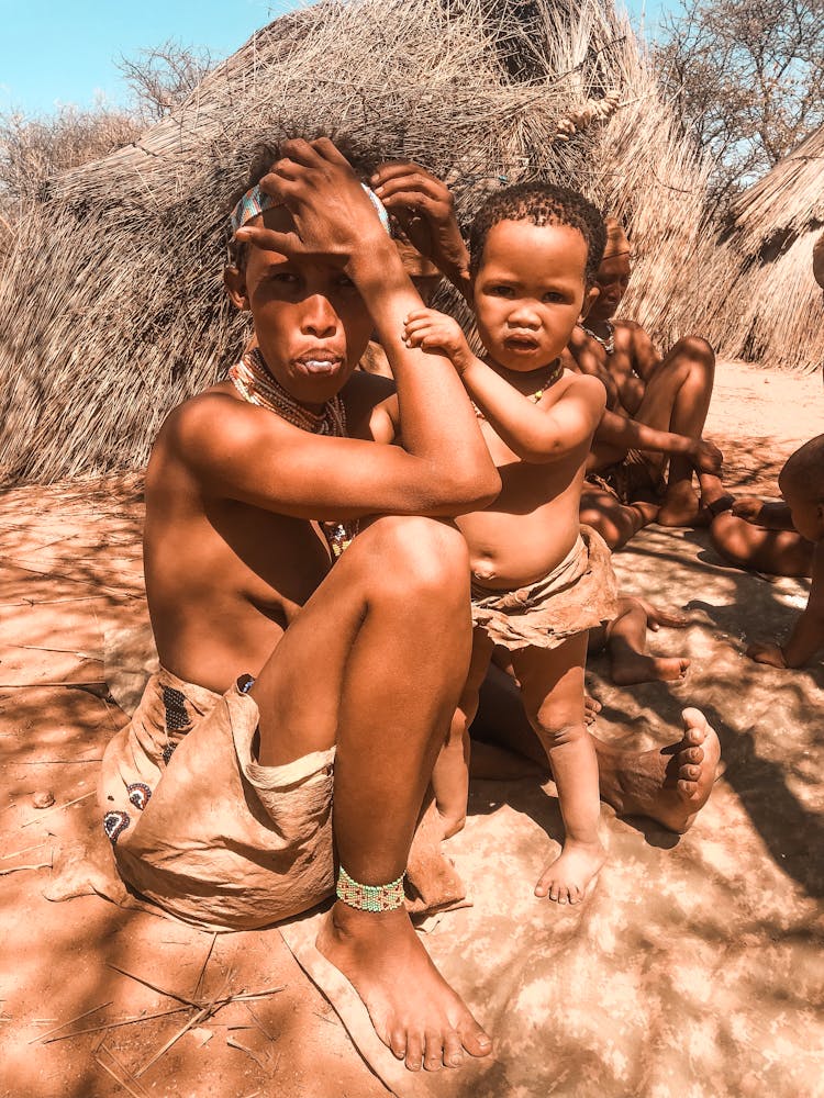 Woman With Child Sitting On Sand